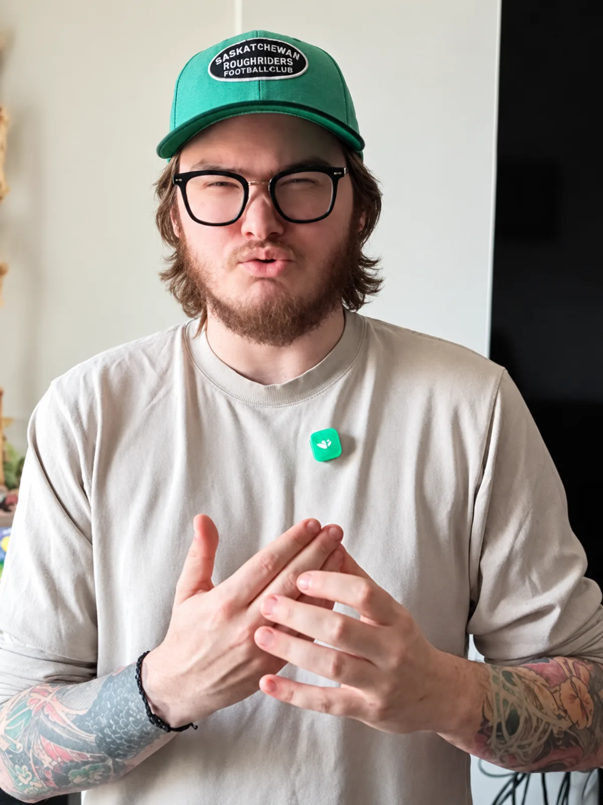 Wyatt McPherson, founder of Cadenic Studios, mid-sentence in a Saskatchewan Roughriders cap.